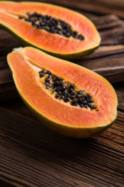 Olgun bir papaya, tahta bir kütükte ikiye bölünmüş..