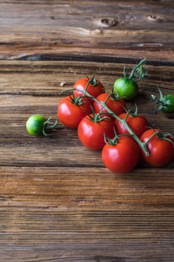 Taze olgun domatesler eski bir kesim tahtasının üzerinde, eski, koyu bir tahta masa..