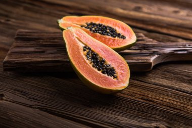 Olgun bir papaya, tahta bir kütükte ikiye bölünmüş..