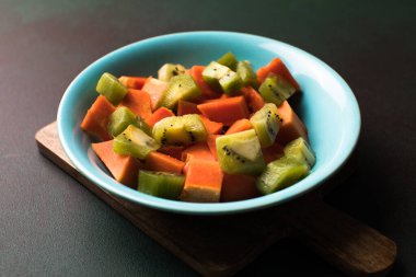Çiğ tropikal meyvelerin sağlıklı vejetaryen kahvaltısı. Bir kase taze kivili papaya. Sağlıklı meyve salatası..