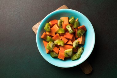 Çiğ tropikal meyvelerin sağlıklı vejetaryen kahvaltısı. Bir kase taze kivili papaya. Sağlıklı meyve salatası..