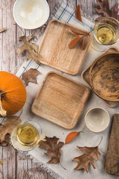 Şükran Günü yemeği. Şükran Günü. Sonbahar yaprakları beyaz boş tabak, kırmızı peçete ve ahşap arka planda çatal bıçak..