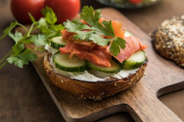 Tütsülenmiş somon, salatalık ve kremalı peynirli sandviç.