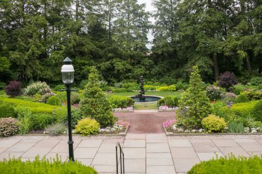 Çiçek açan çiçek tarlaları, canlı mevsimlik çiçekler ve yemyeşil bitkilerle dolu manzaralı bir bahçe. Bahçıvanlık, peyzaj, bahar ve yaz temaları ya da doğa teması için mükemmel. Çevre dostu yaşam tarzı için ideal, açık hava tasarımı,