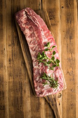 Mutfakta ızgaraya hazır bir kesme tahtasında taze domuz pirzolası.