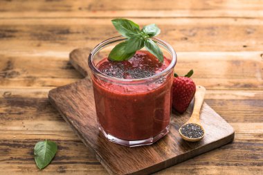 Çilekli smoothie, chia tohumu ve taze fesleğen yaprağı. Sağlıklı yaz içeceği, vitamin ve antioksidan açısından zengin, temiz bir yaşam tarzı için mükemmel.