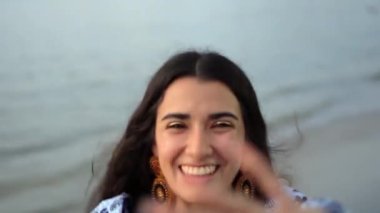 Genç gezgin gülümsüyor ve sahilde eğleniyor.