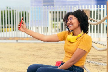 Kadın akıllı telefondan bir arkadaşıyla görüntülü konuşma yapıyor.