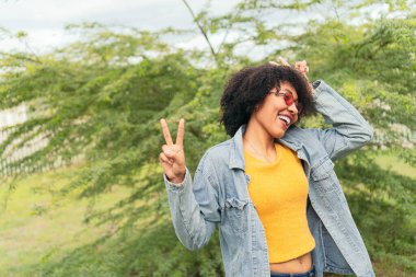 Doğuştan yeşil arka planda duran Afro kadın dans ediyor..