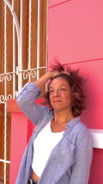 Усміхнена Жінка Спирається Рожеву Стіну — стокове відео