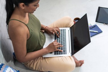 Evde dizüstü bilgisayarla çalışan bir kadın. E- posta yazılıyor.