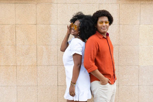 Afro couple back to back standing in the street