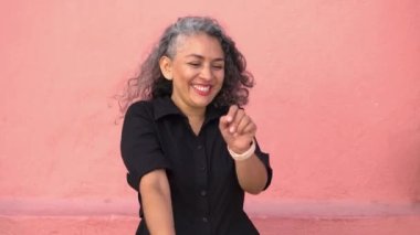 Carefree older woman enjoys dancing in the street