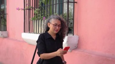 Mature Woman Using Mobile Phone In The Street