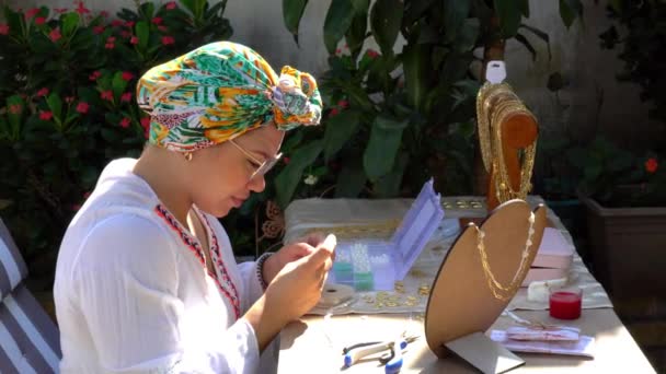 女性がネックレスを作りお土産や工芸品を市場で販売し — ストック動画