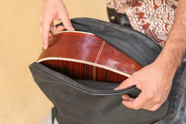 stock image street musician unpacking his guitar in the street