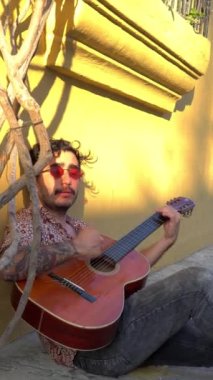 Şehirde gitar çalan Latin müzisyen.