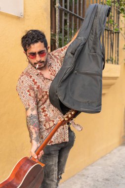 Sokak müzisyeni gitarını açıyor.