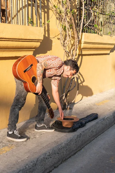 Latin Man collecting money after performance on street