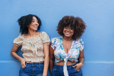 Duvarın önünde duran iki Afro-Amerikalı kadın..