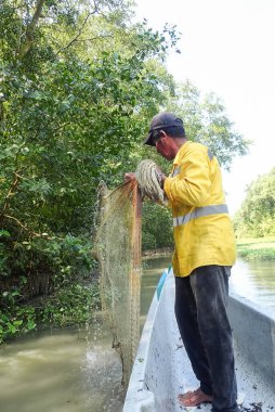 Latin balıkçı ağlarını topluyor..