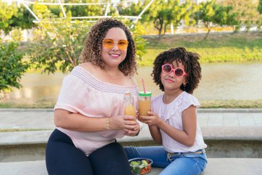 Anne ve kızı yaz boyunca parkta vakit geçiriyorlar.