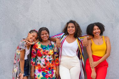 Genç yetişkinler, basit gri bir ortama karşı birlikte ışıldıyorlar.