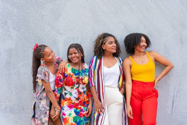 Gri bir arka planda birlikte gülümseyen arkadaşlar