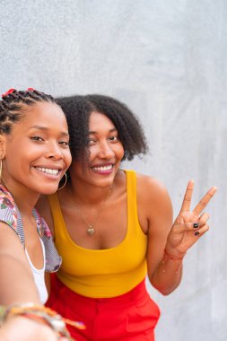 Yüzlerinde geniş bir gülümseme olan iki Afro-Amerikalı arkadaş..