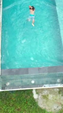 Yüzme havuzunun kenarında gezinin tadını çıkaran bir kadın..