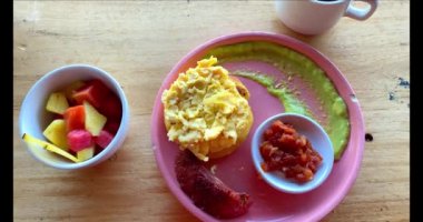 Meyve, yumurta, kahve ve arepa ile Kolombiya kahvaltısı manzarası. Arkaplanda dağlar