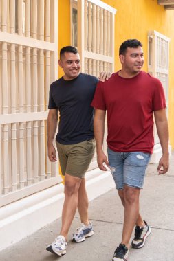 İki arkadaş, yoldaşlık hissiyle şehir caddesinde rahat bir yürüyüş yapıyorlar..