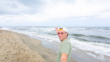 Güneş gözlüklü Latin adam güneşli sahilde