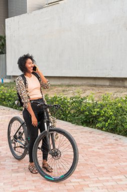Telefondaki bisikletli gülümseyen kadın..