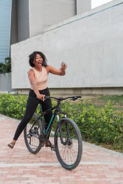 Dışarıda bisikletle gülen neşeli bir kadın..