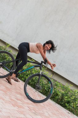 Latin bir kadın şehirde bisiklet sürmekten hoşlanıyor.