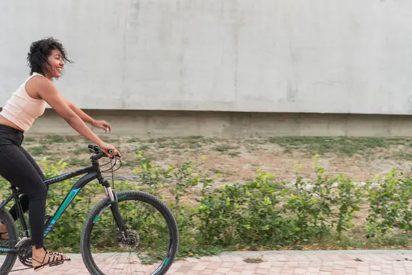 Güneşli bir günde bisiklete binen Latin Kadın