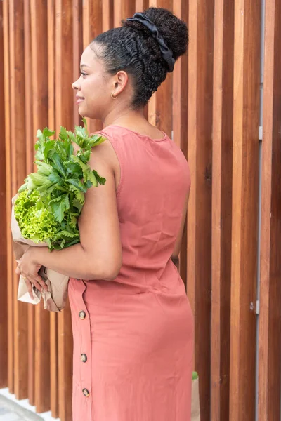 Somon elbiseli şık bayan taze yeşillik taşıyor..