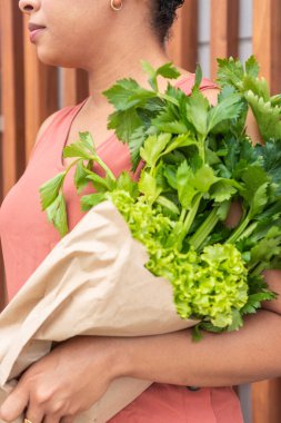 Bir kadının bir demet taze marul ve maydanozu kucaklayışını yakından görmek..
