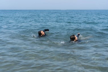 Sakin okyanus sularında yüzen iki birey.