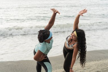 İki kadın dalgalar tarafından spor yaparken çekilen hareketli bir gerinme anı..