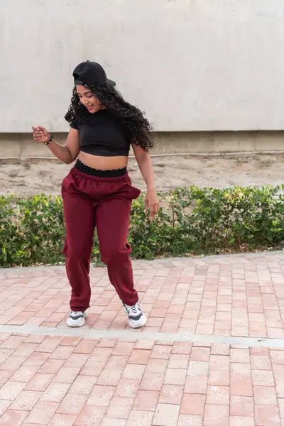 stock image Young woman in casual wear dancing hip-hop in an urban outdoor setting.