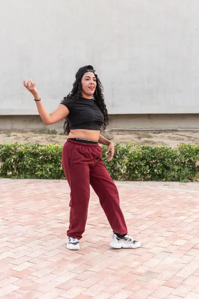 stock image Young woman in casual athletic wear expressively dancing hip-hop outdoors.