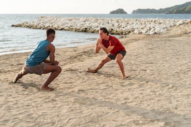 Kumsalda faal bir frizbi oyunu oynayan iki adam..
