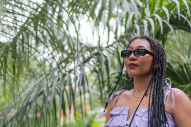 Saçları örgülü Afrikalı Kadın Lush Garden 'da dinleniyor