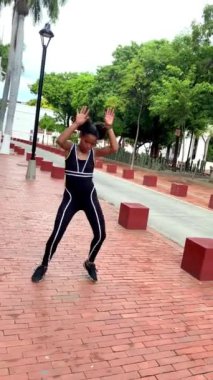 Genç şehir dansçısı taştan bir duvarın önünde modern bir koreografi sergiliyor.