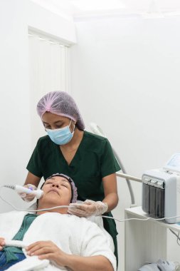 Yetenekli güzellik uzmanı cilt sağlığını ve görünüşünü iyileştirmek için yüz bakımını gençleştirmek için ileri teknoloji kullanıyor.