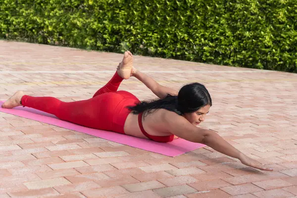 İspanyol kadın dışarıda pilates egzersizi yapıyor, fiziksel aktivite yoluyla sağlığını ve sağlığını destekliyor.