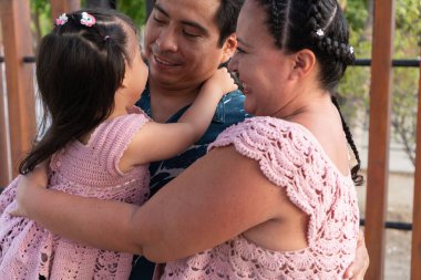 Mutlu İspanyol anne babalar küçük kızlarına sarılıyor, gülümsüyor ve birlikte vakit geçiriyorlar.