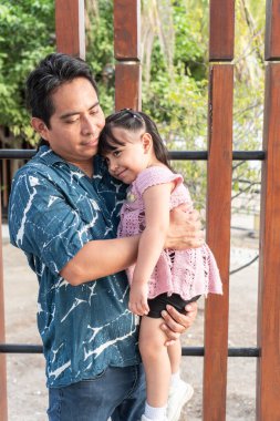 Aborjin İspanyol bir baba genç kızını kollarında tutuyor, sevgi ve sevgi gösteriyor.